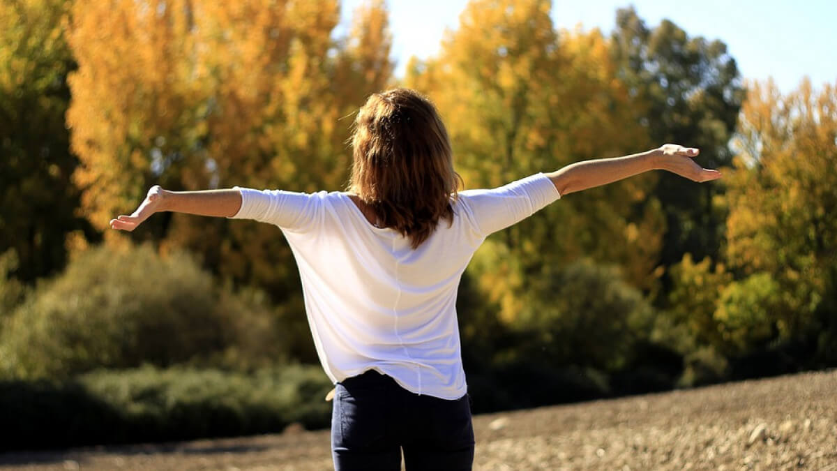 Mujer con los brazos abiertos al sol